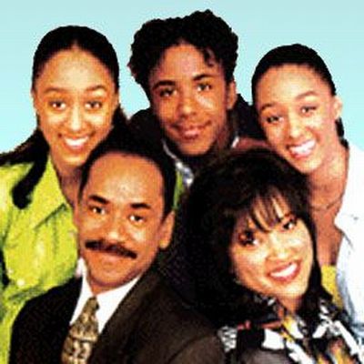 Cinco personas, dos mayores y tres adolescentes con caras sonrientes