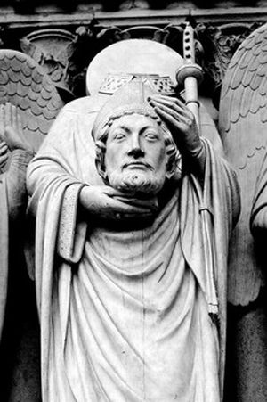 Una estatua de un hombre  decapitado que lleva su propia cabeza en sus manos