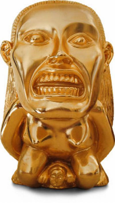 Vemos una máscara en color dorado   con ojos muy grandes y  muestra sus dientes 