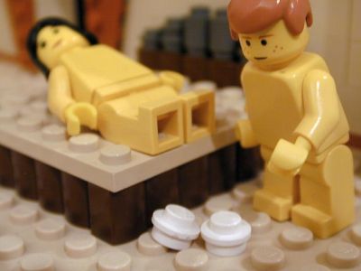 Unos muñecos, uno recostado en una especie de cama y al lado el otro muñeco 