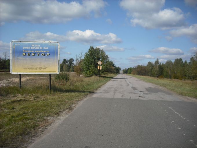 Vemos una carretera con árboles y unos  carteles  que  dicen algo en otro idioma   