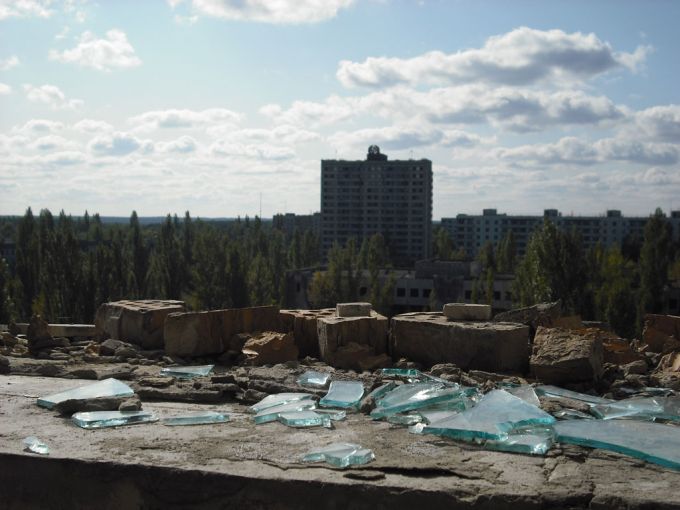 Vemos un edificio grande a lo lejos, vegetación y muchos bloques de hormigón en el sitio