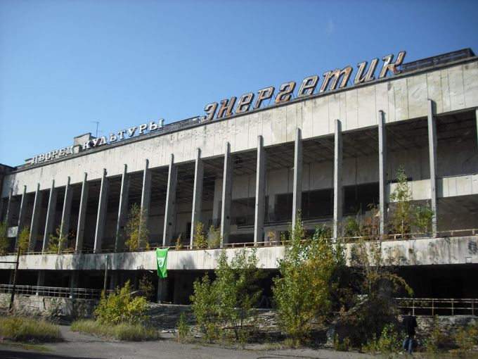 Vemos una edificación no muy destruida, grande y blanca y también mucha vegetación se ve