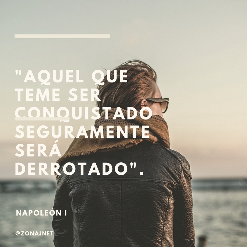 Una mujer sola de espaldas con gafas y chaqueta mirando hacia el mar