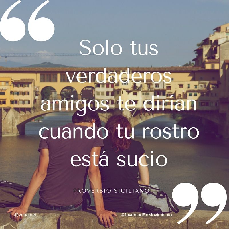 Pareja de novios sentados al borde de un puente en una ciudad europea