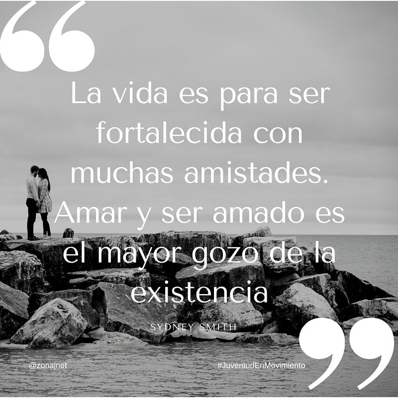 Una pareja en la playa sobre un rompeolas con el mar en calma