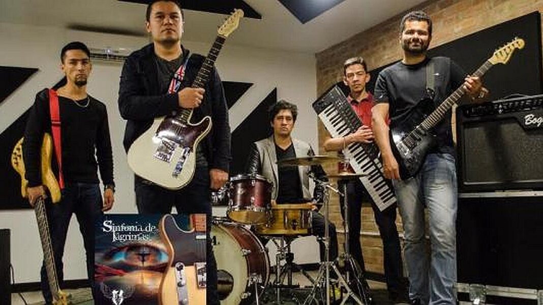 Cinco músicos posan en una sala de ensayo: dos con guitarras eléctricas, uno con bajo, otro con teclado y un baterista; abajo se ve una portada de disco.