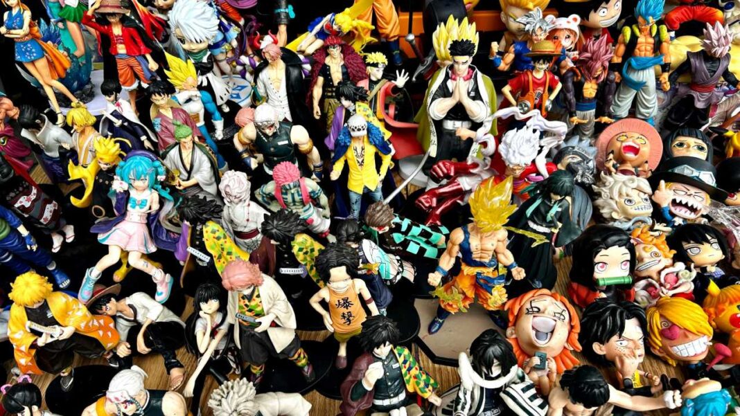 Gran grupo de figuras de anime de distintos colores y poses sobre una superficie, vistas desde arriba en una colección densa.